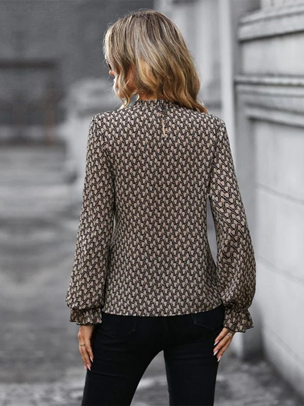 Back view of a woman wearing a brown and black printed long-sleeve blouse.