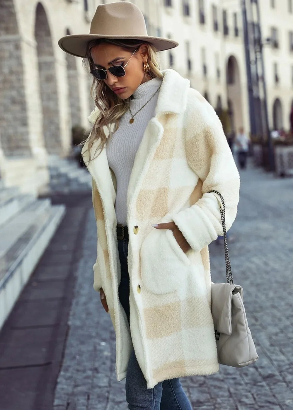 Cream and tan plaid fuzzy coat with gold buttons and a relaxed fit on a woman wearing a hat and sunglasses.
