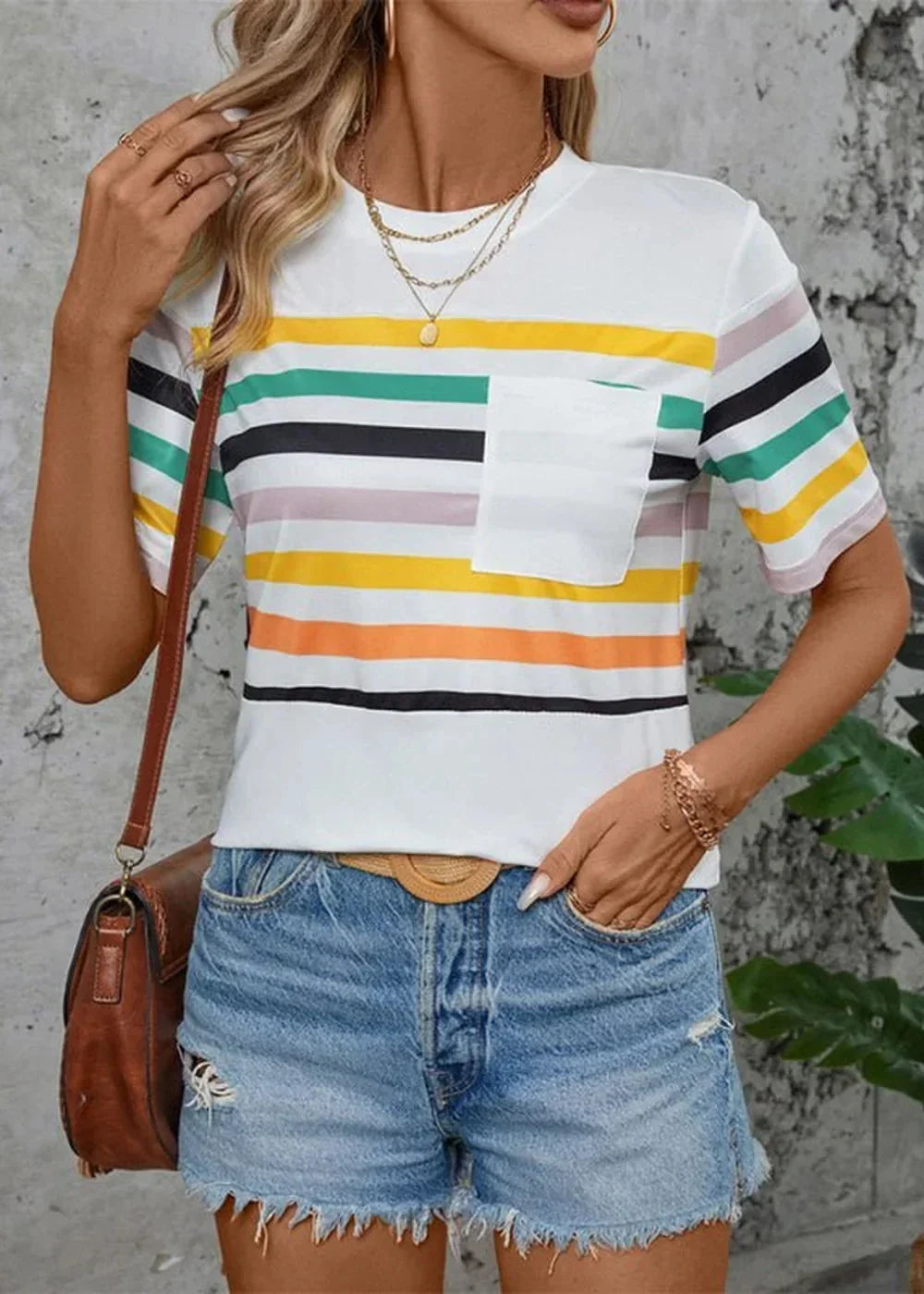 White striped t-shirt with pocket, paired with distressed denim shorts and brown crossbody bag.