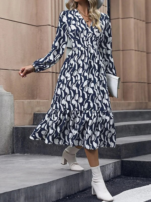 Navy and white abstract print midi dress with long sleeves and a tiered skirt.