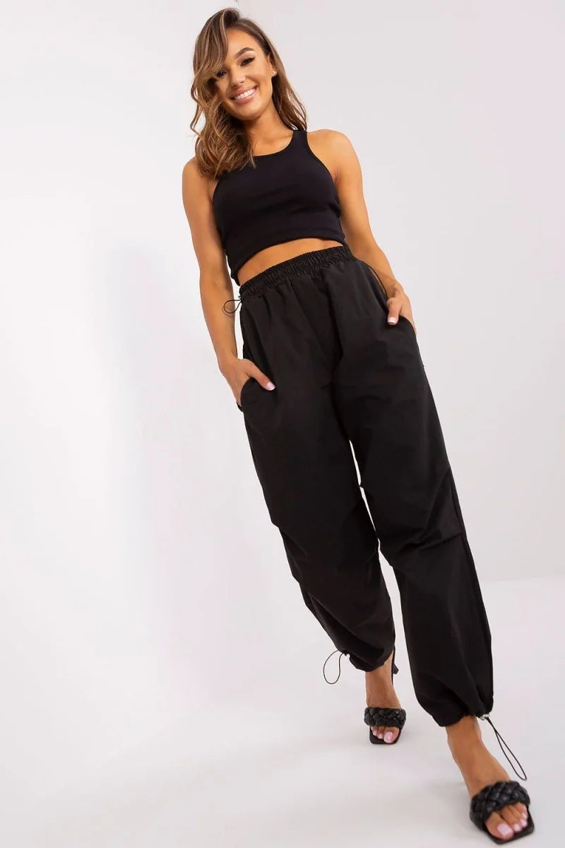 Black cargo pants with drawstring ankles and cinched waist on a model.