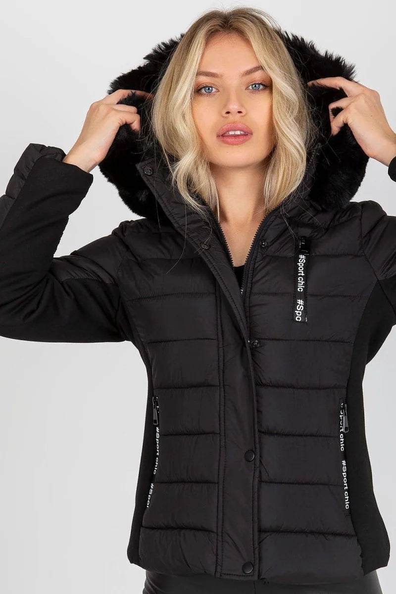 Black quilted puffer jacket with black fur-trimmed hood and contrasting black side panels with white text detail.