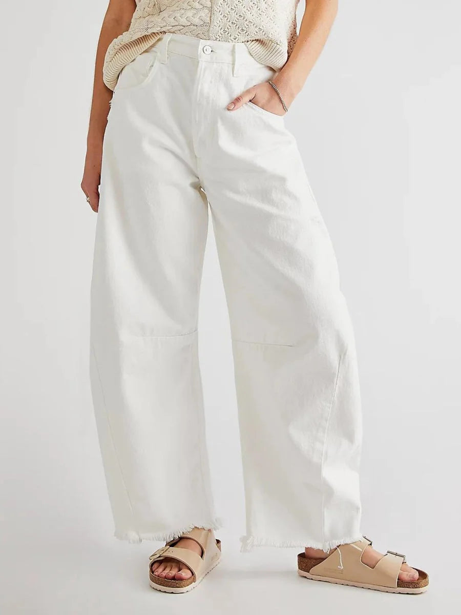 High-waisted white wide-leg pants with frayed hems and a relaxed fit.