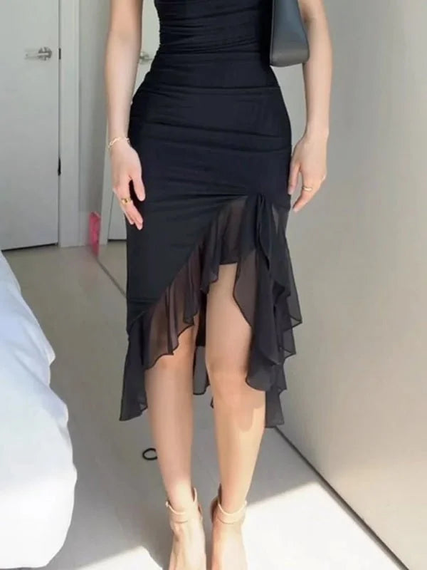 Black ruched midi dress with sheer ruffle hem and ankle strap heels on model