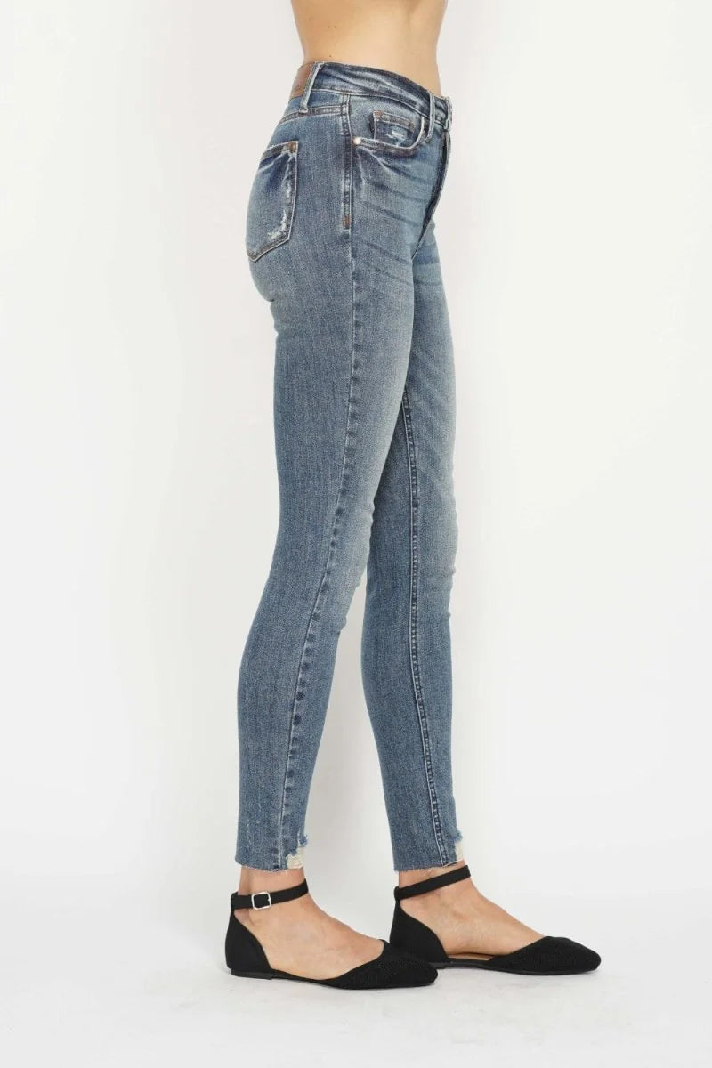 Distressed light wash denim jeans with a frayed hem and moderate stretch, shown on a model from the side.