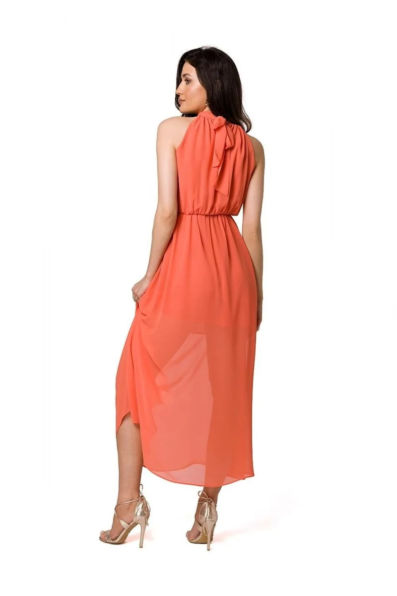 Coral halter maxi dress with a high neckline and flowing skirt, shown from the back on a model.