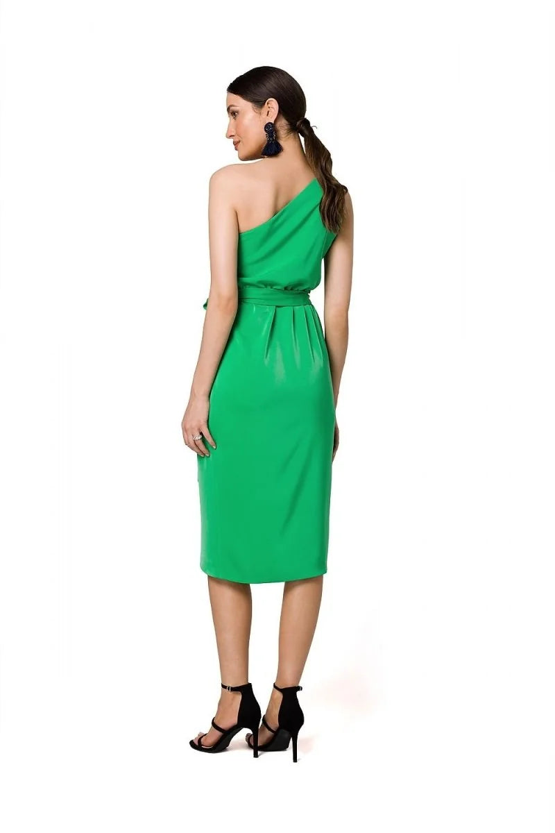 Emerald green one-shoulder midi dress with a belted waist and black strappy heels.