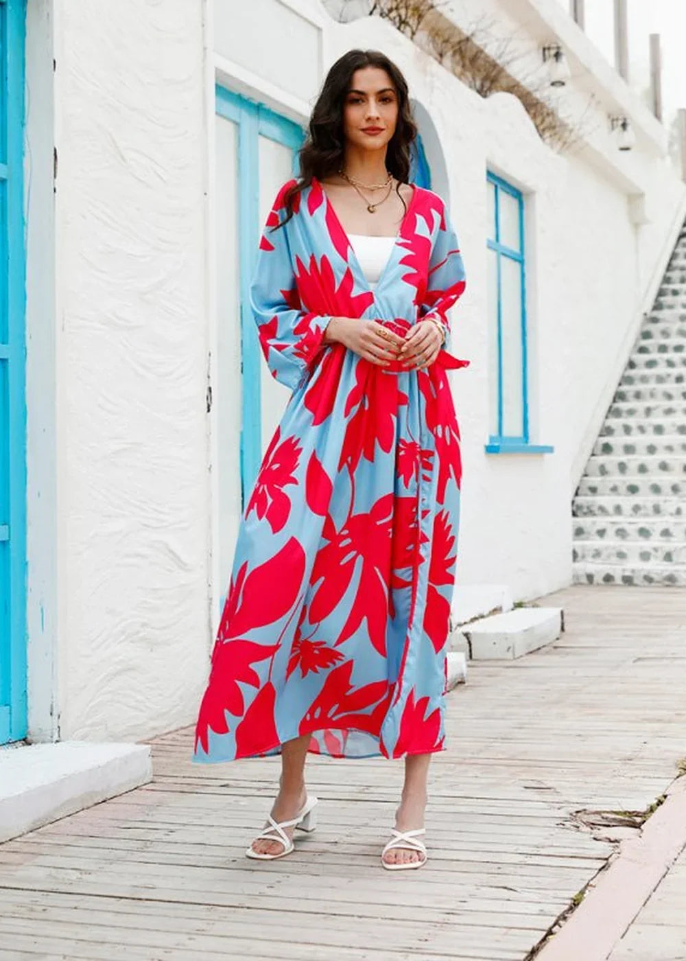 Light blue and red floral print maxi dress with a wrap-style V-neck and white heeled sandals.