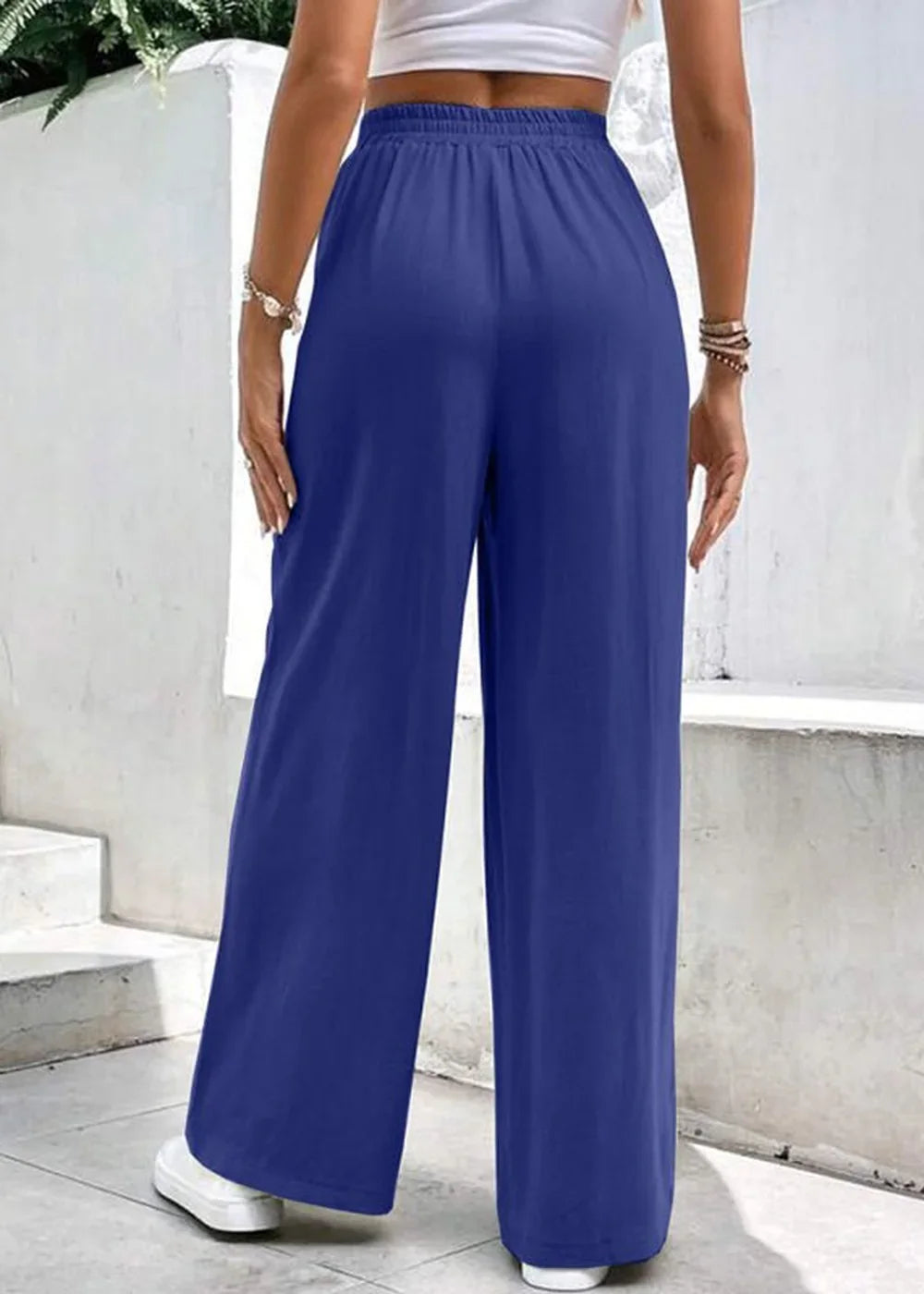 Navy blue wide-leg pants with a comfortable elastic waistband, shown from the back on a model.