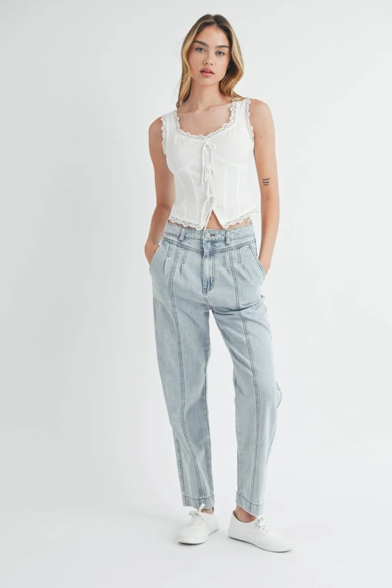 Light wash denim pants with prominent vertical seams and a relaxed fit on a model.