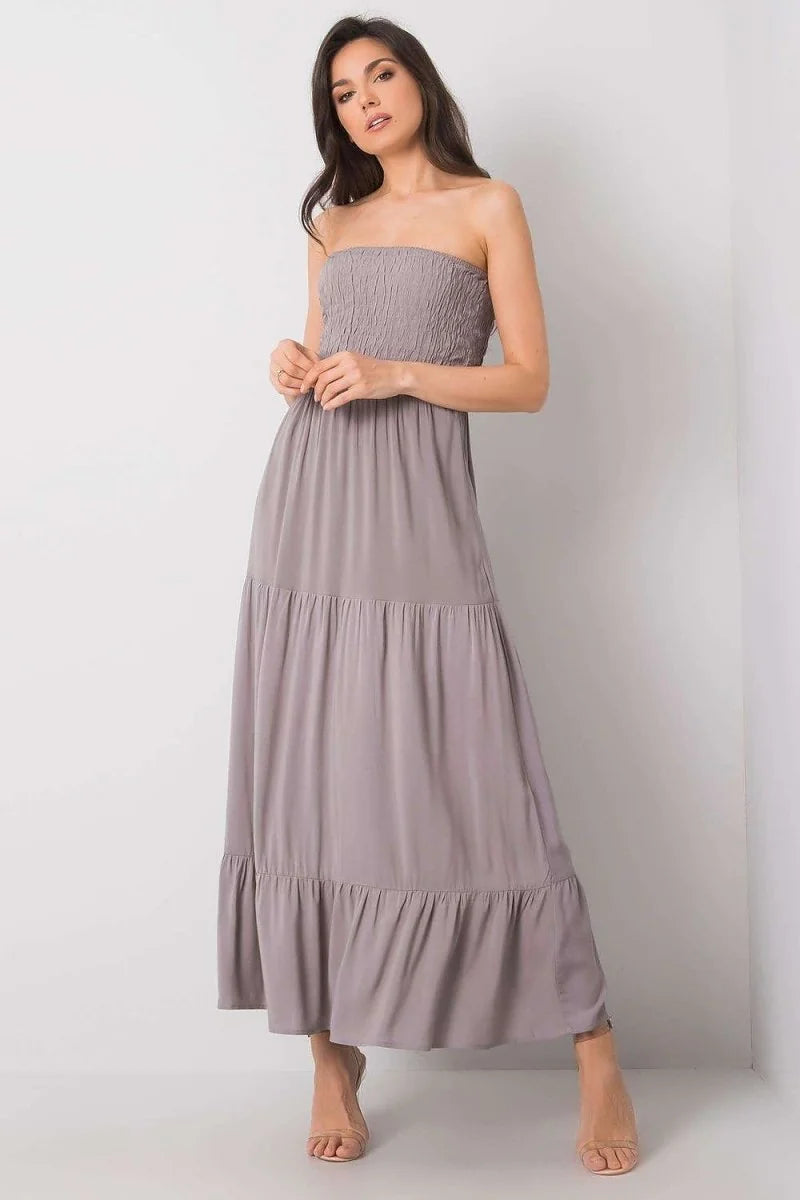 Strapless grey maxi dress with smocked bodice and tiered ruffled skirt, on model.