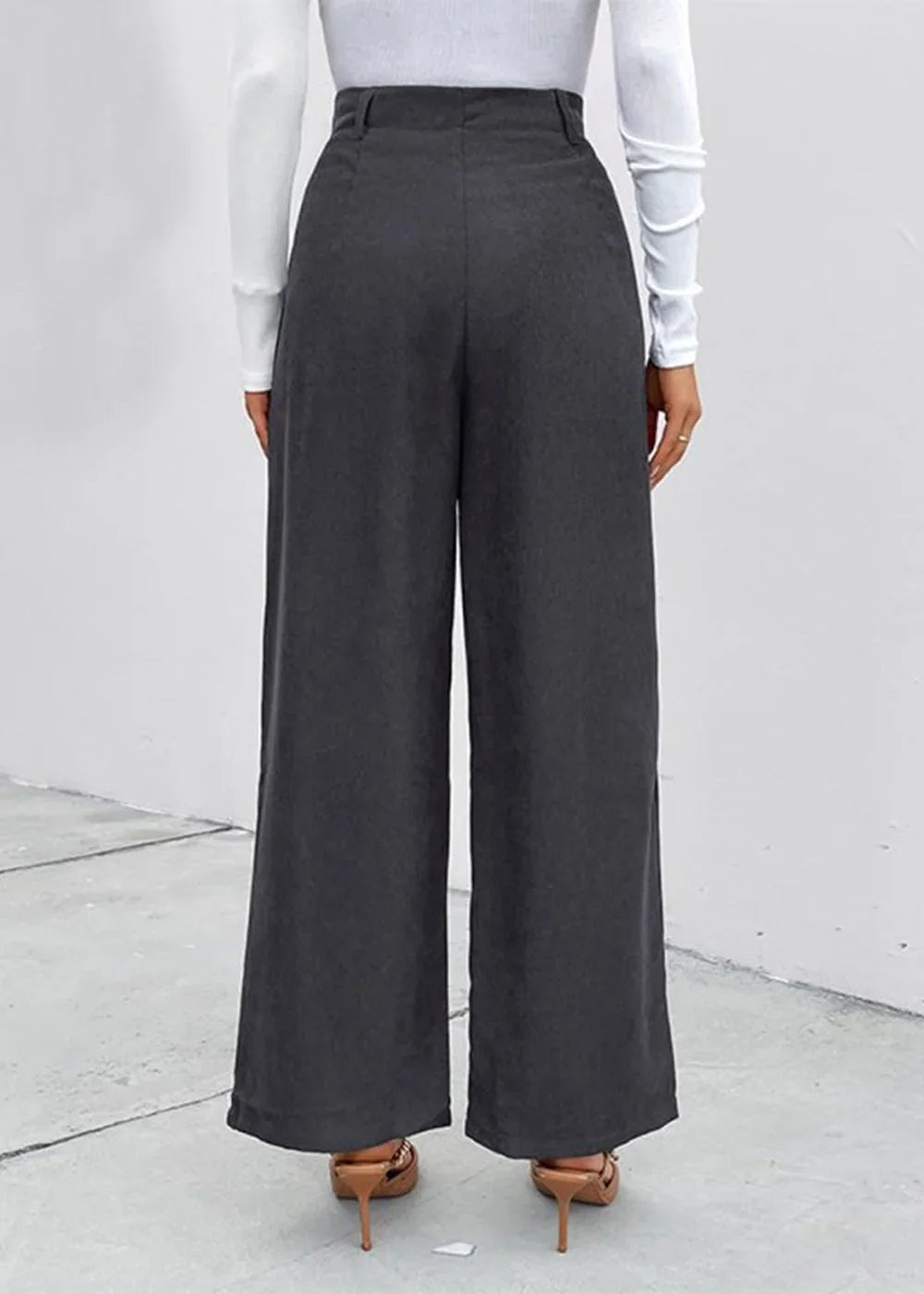 Back view of dark gray wide-leg pants made of polyester, true to size, on a model wearing heels.