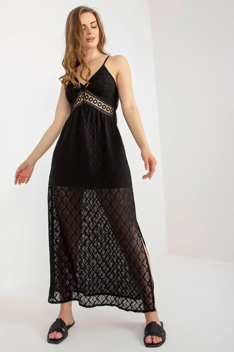Black lace maxi dress with a V-neck, empire waist, and thigh-high slits, worn with black slides.