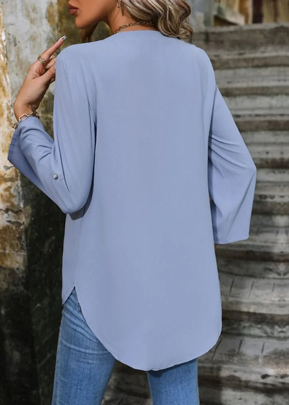 Light blue long-sleeve tunic top with rolled sleeves, on a model wearing jeans.