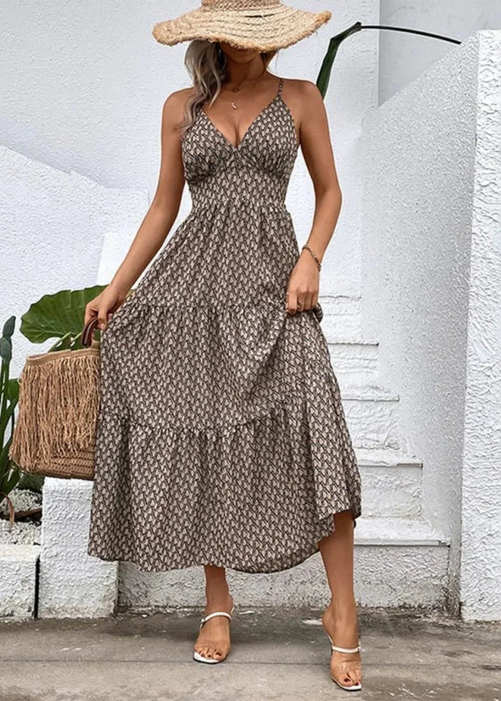 Khaki tiered maxi dress with a geometric print, spaghetti straps, and a straw hat.