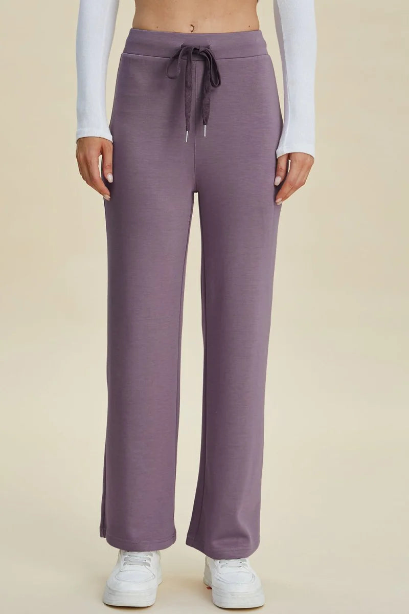 Lavender wide-leg sweatpants with drawstring waist and white sneakers.