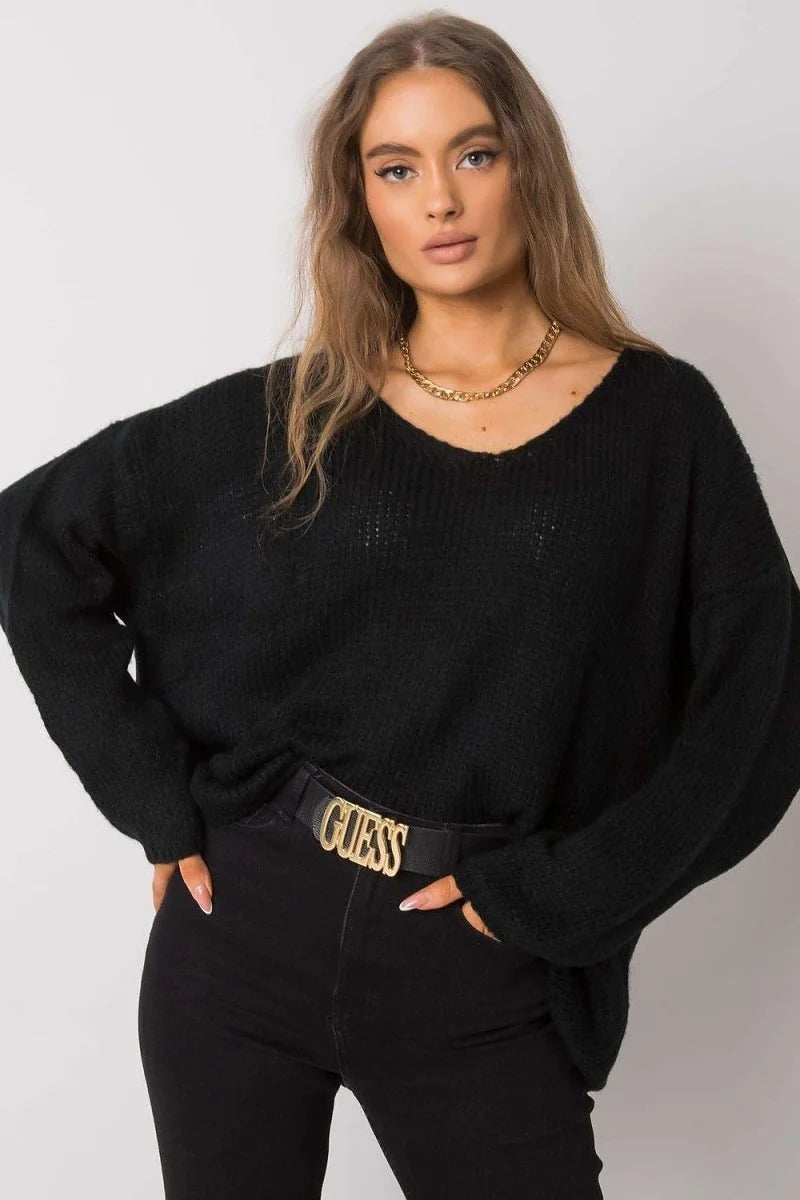 Black V-neck sweater with a gold chain necklace and black belt with gold "GUESS" logo.