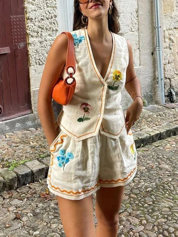 Beige embroidered floral vest and shorts set with orange trim.