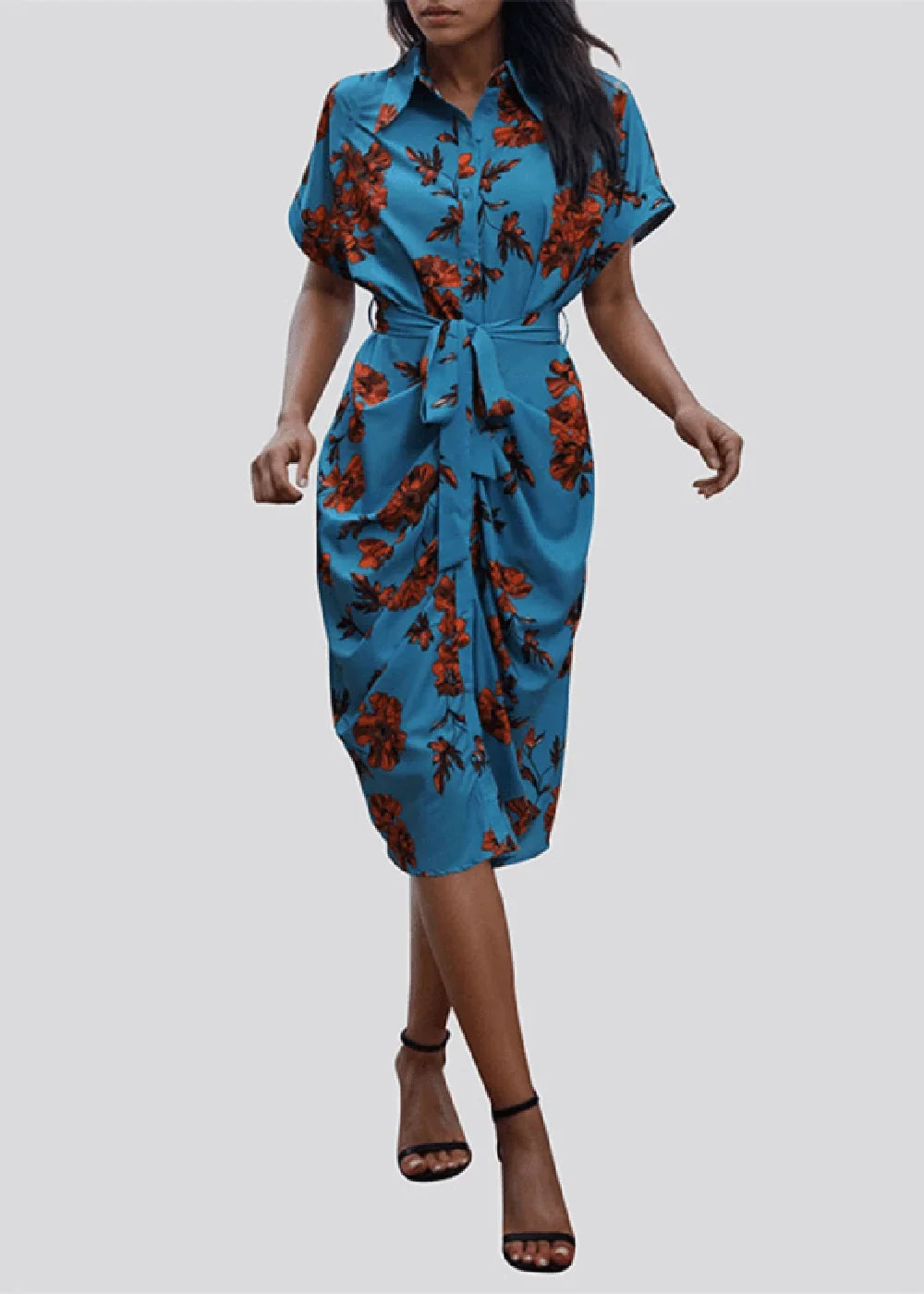 Blue floral print shirt dress with tie waist and draped skirt, worn with black strappy heels.