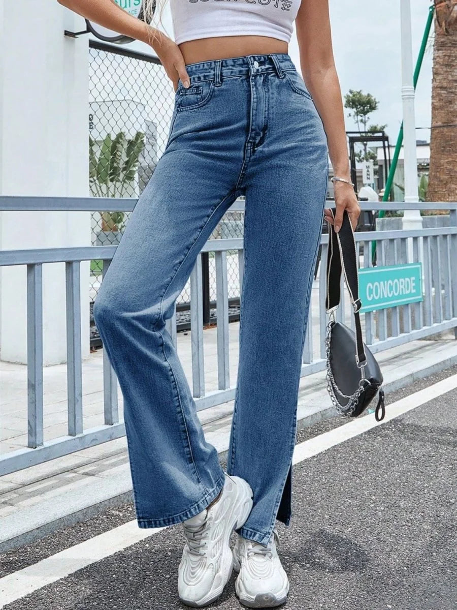 Woman in light blue denim jeans with a high waist and straight leg, paired with white sneakers.