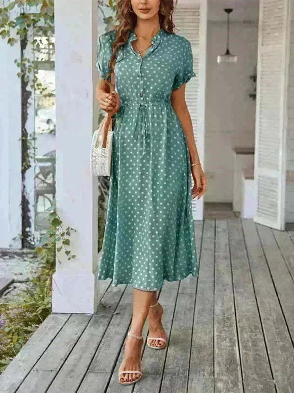 Green polka dot midi dress with short sleeves, drawstring waist, and heeled sandals.