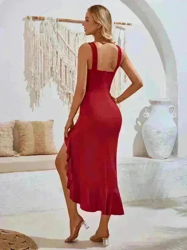Red midi dress with a ruffled hem and high slit, worn by a woman with clear heeled sandals.