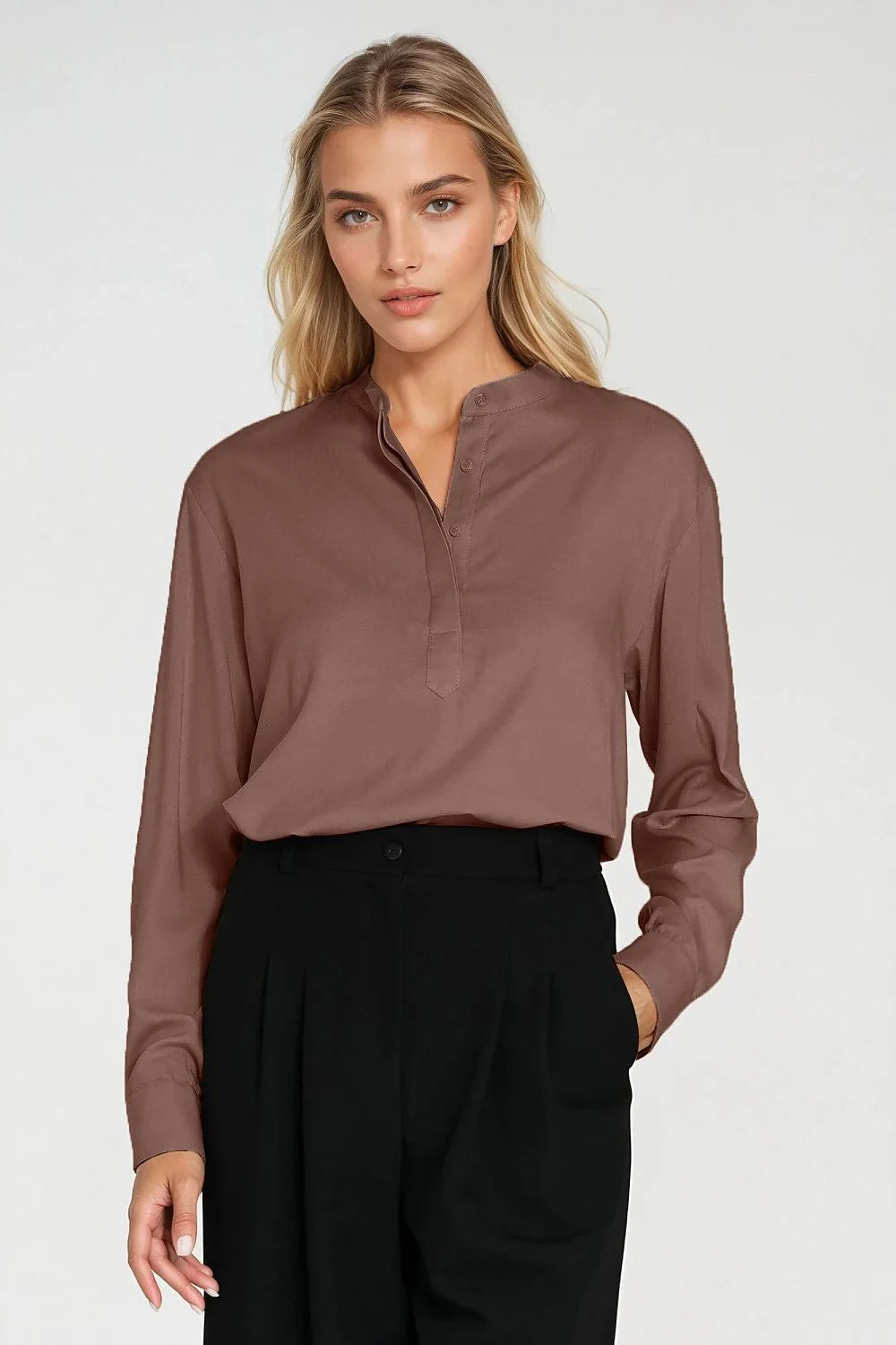 Woman in a brown collared blouse and black pleated trousers.