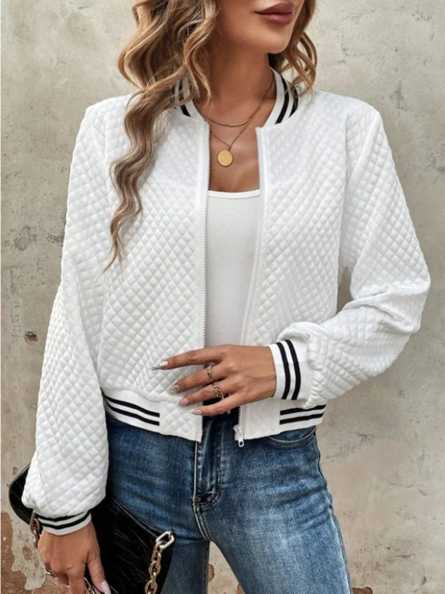 White quilted bomber jacket with black striped trim and ribbed cuffs on model.