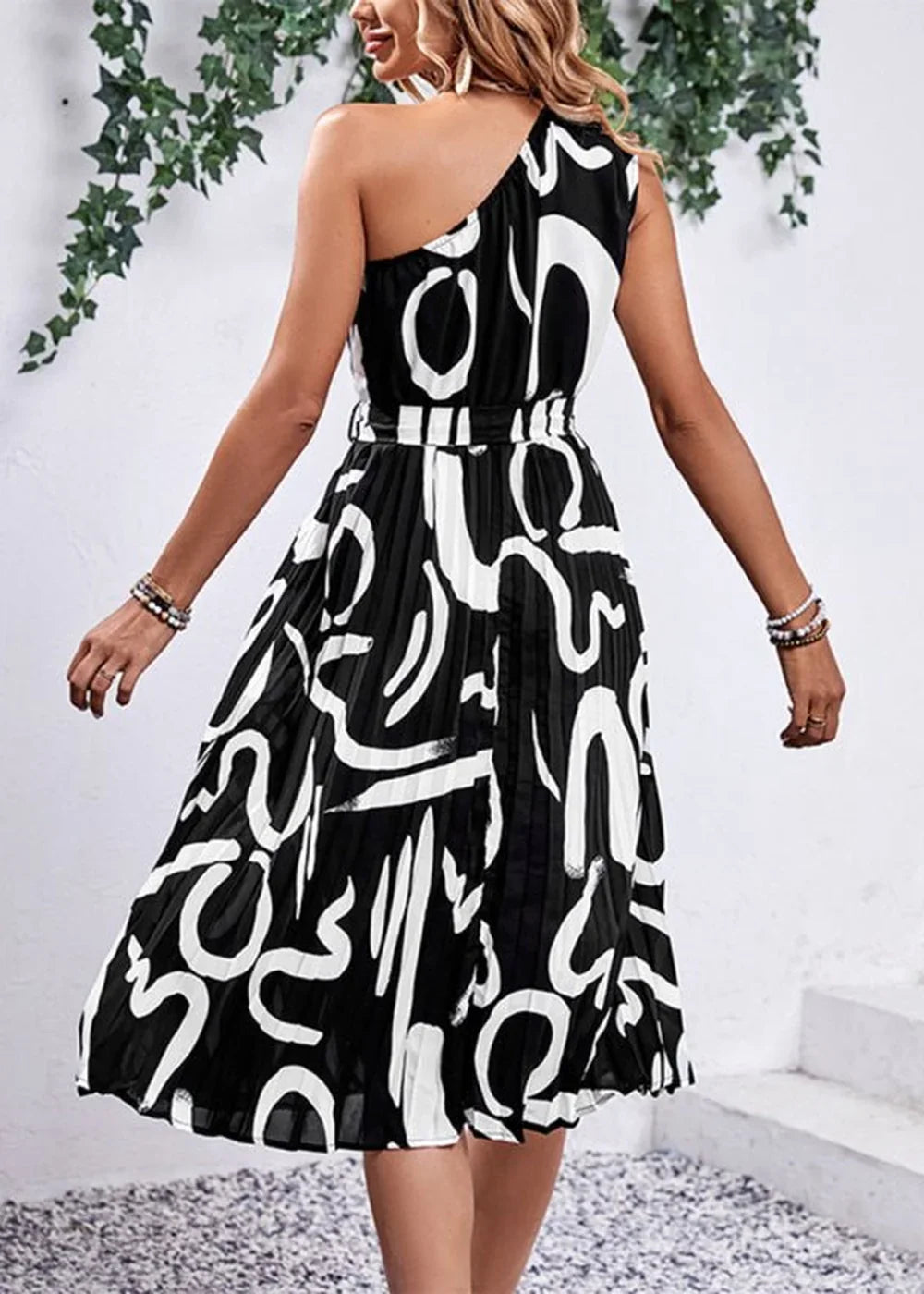 Black and white abstract print one-shoulder pleated midi dress with a belted waist.