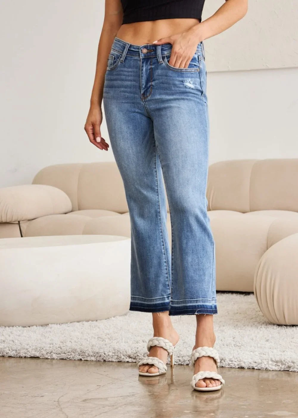 Medium wash denim jeans with frayed hem and a slight flare.