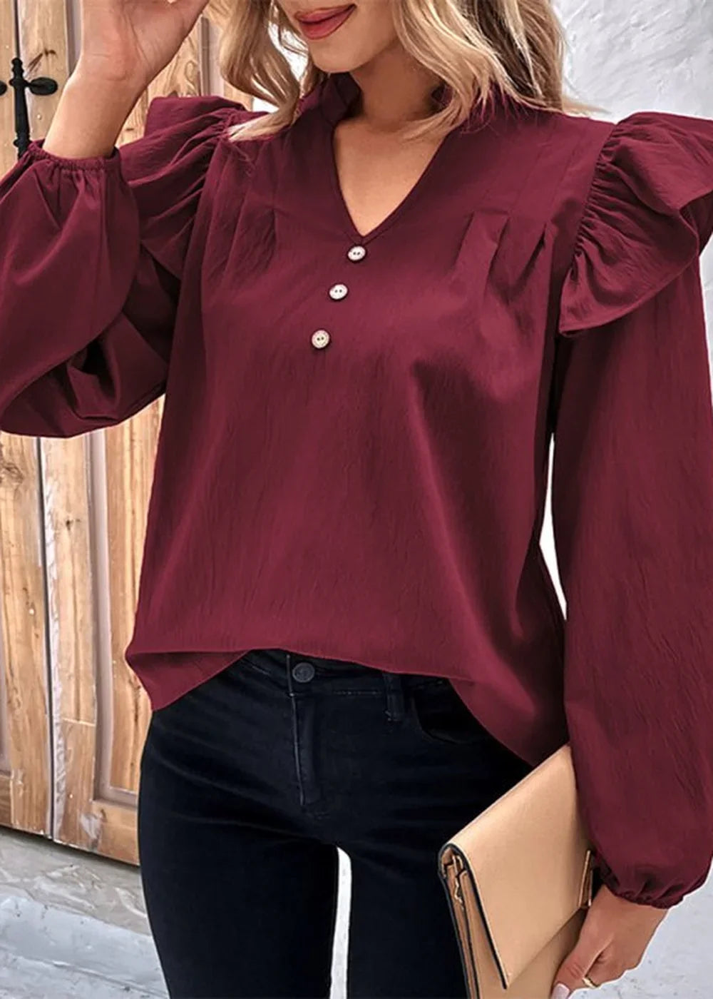 Maroon ruffled long-sleeve top with v-neck and button detail.