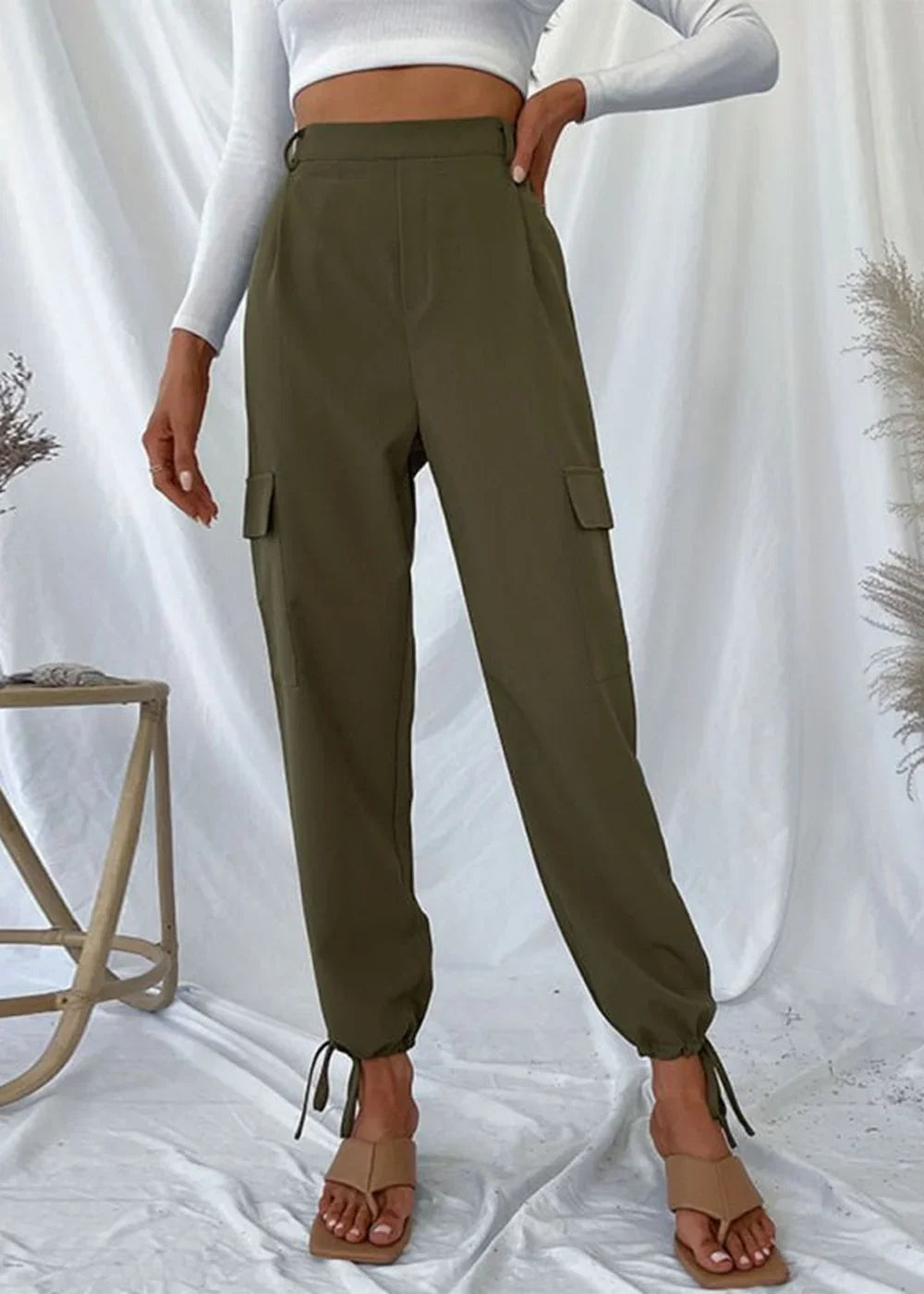 Olive green cargo pants with tie ankles, seen on a model wearing tan sandals.