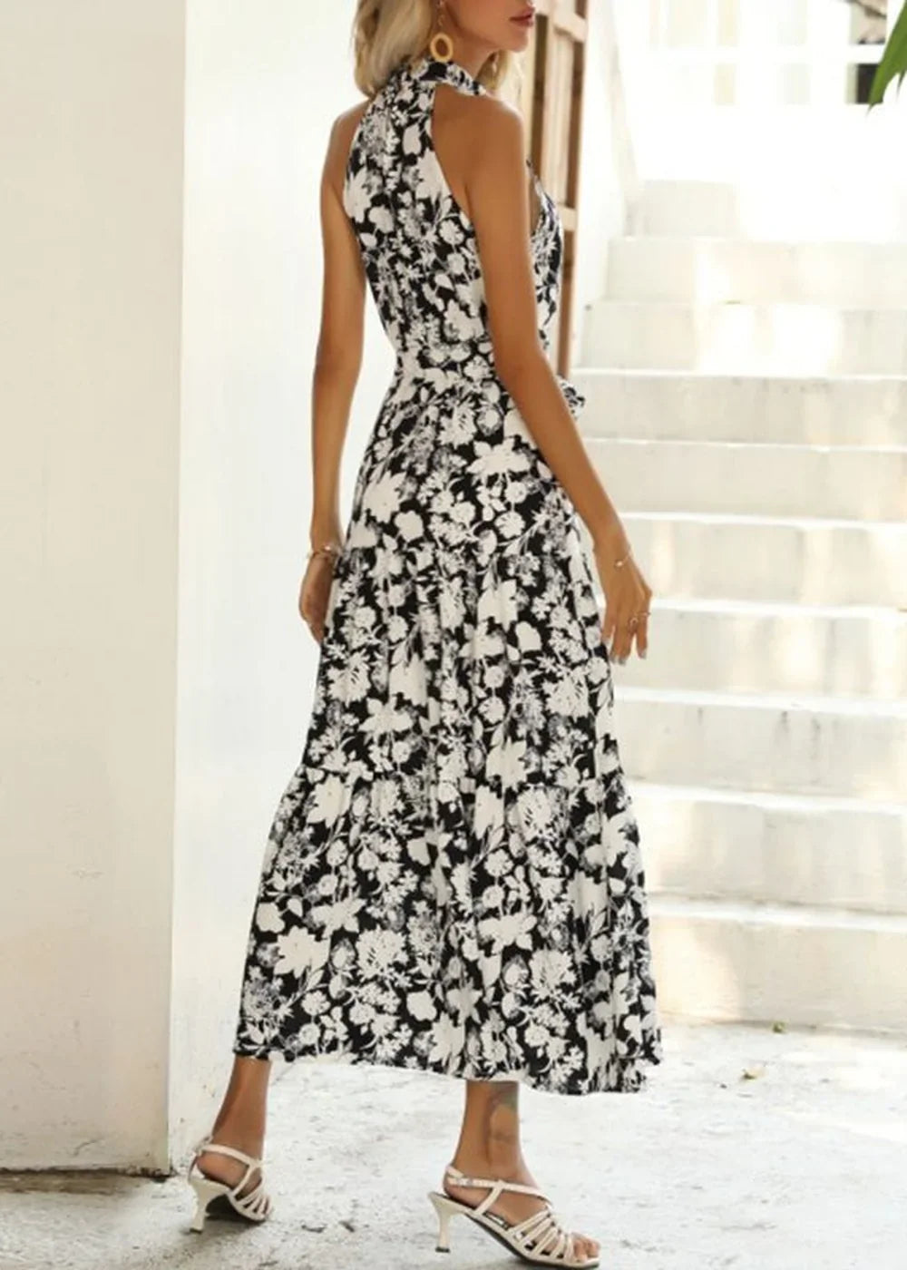 Black and white floral print halter maxi dress with white strappy heels.