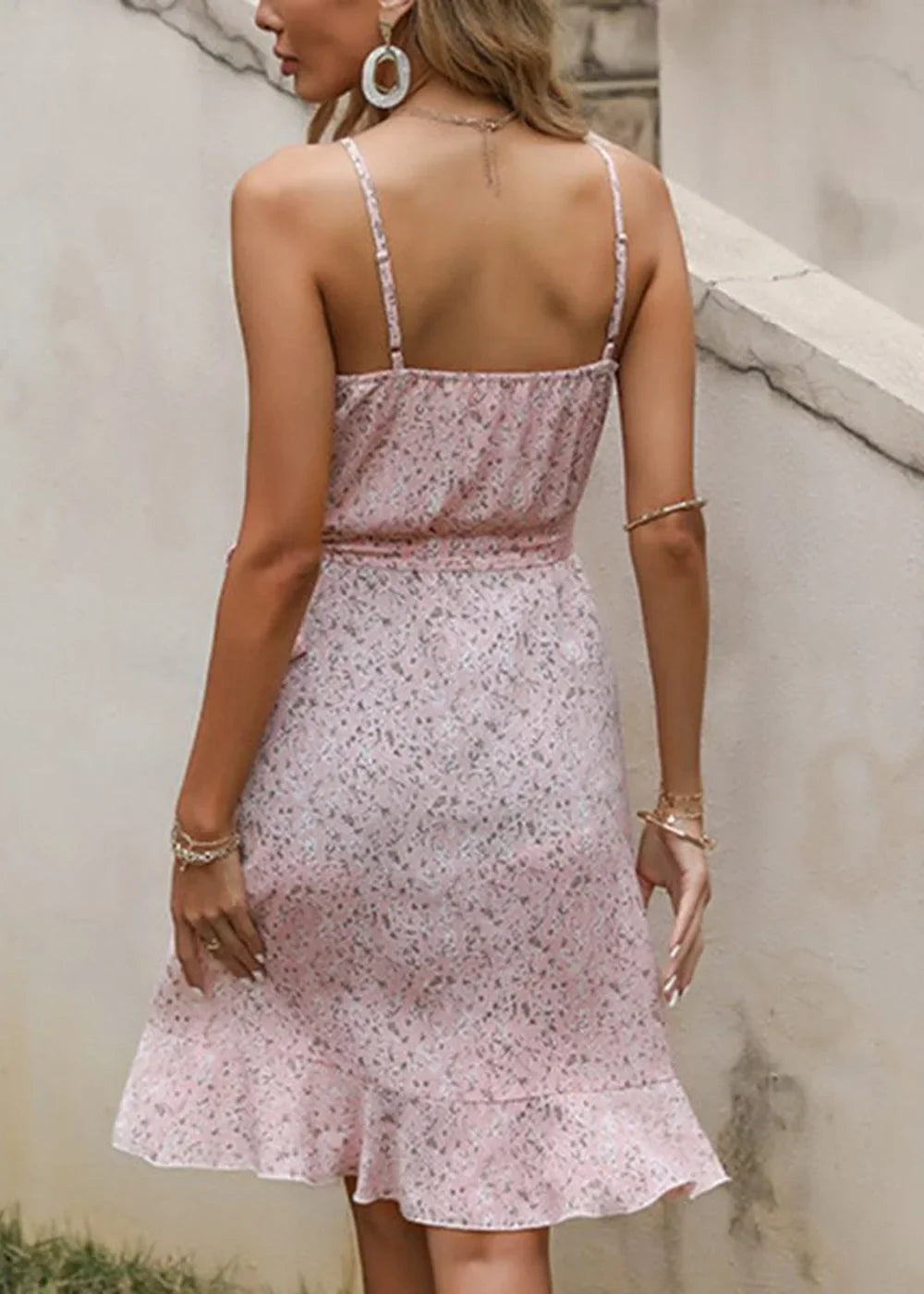 Pink floral print mini dress with ruffled hem and spaghetti straps, shown from the back.