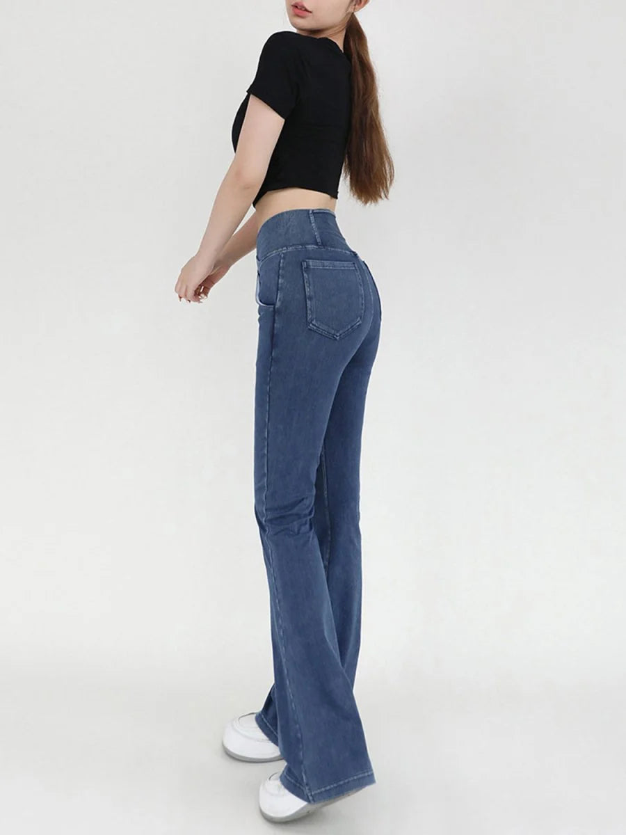 Blue denim flare jeans with a high waist, shown on a model from the side.