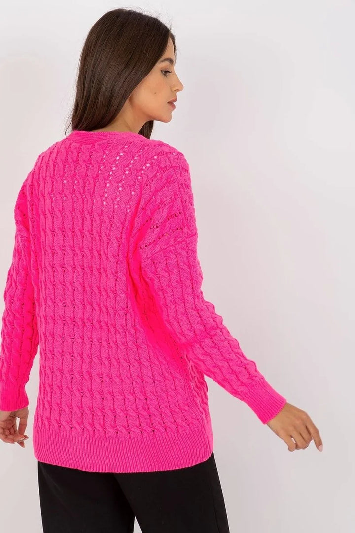 Bright pink knit sweater with a cable knit pattern and ribbed cuffs, showing the back of the garment on a model.