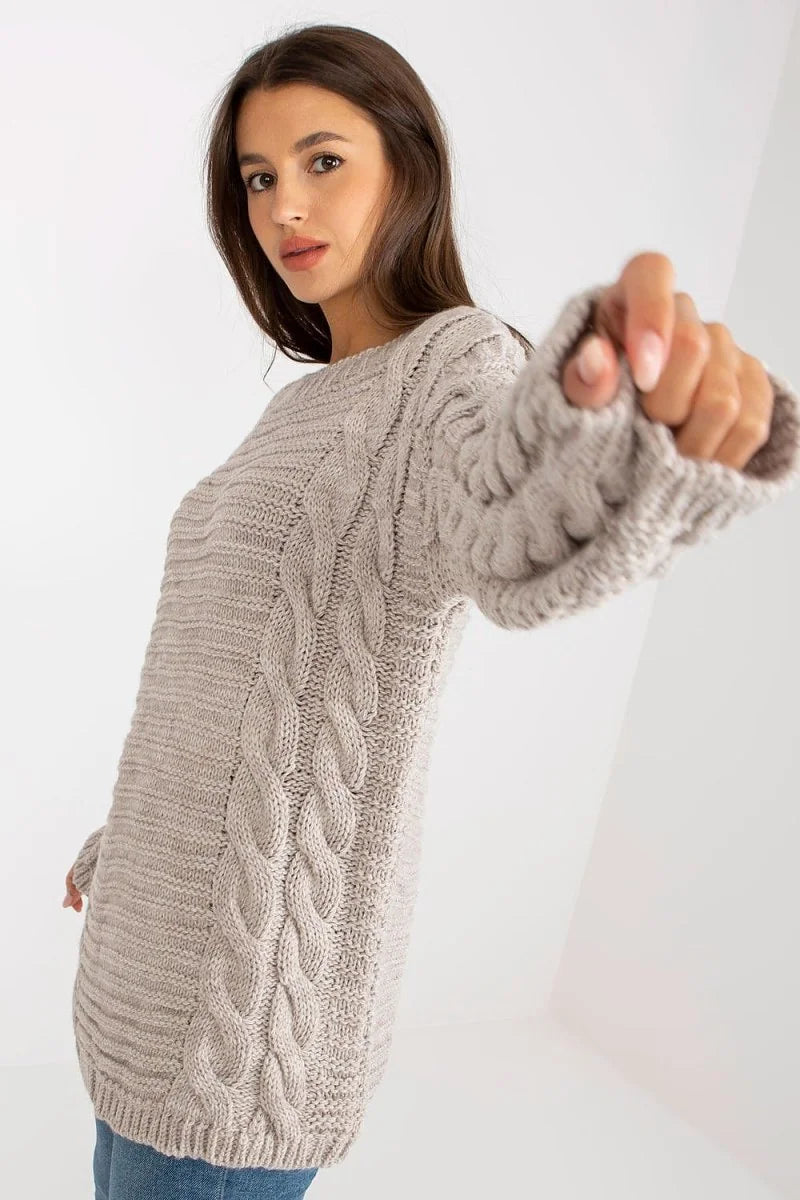 Light beige knit sweater with cable knit detailing on the front and sleeves, on a model.