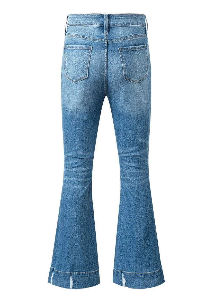 Back view of light blue distressed denim flare jeans with frayed hem.