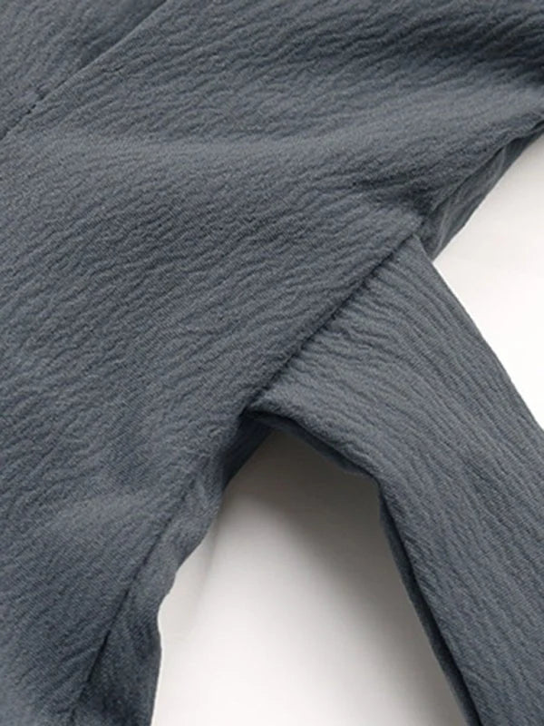 Close-up of textured, dark gray polyester fabric with a subtle crinkled pattern.