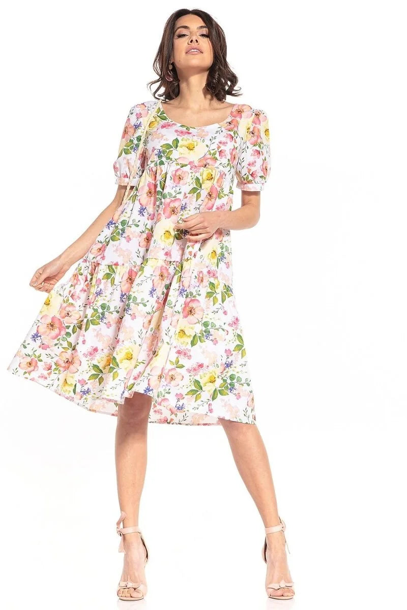 Relaxed fit white cotton dress with a vibrant pink, yellow, and blue floral pattern and puff sleeves.