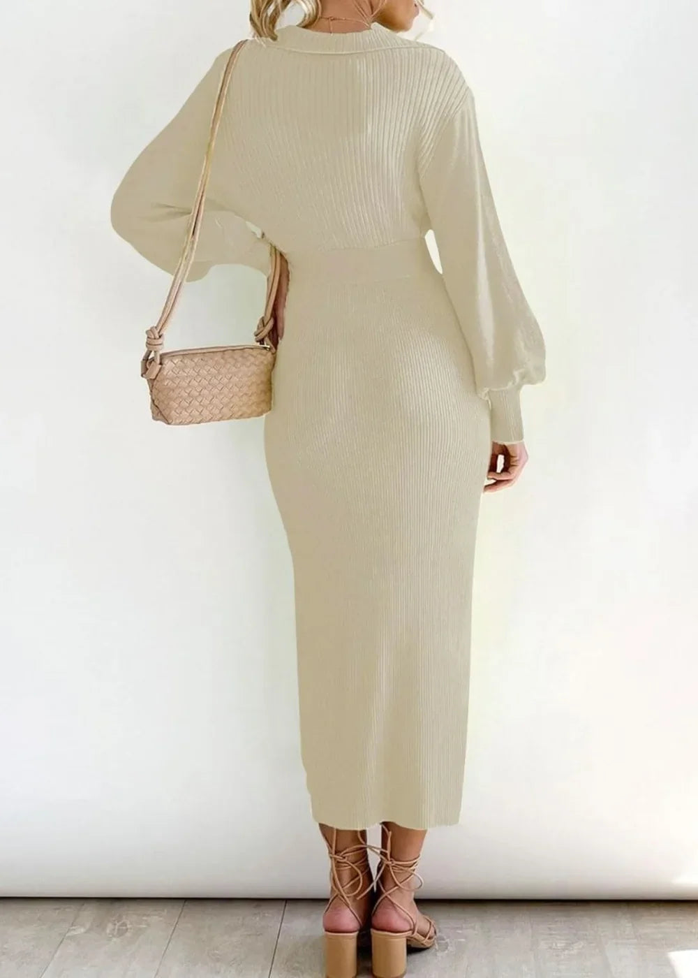 Cream ribbed knit sweater dress with balloon sleeves and a midi length, worn with strappy heels.