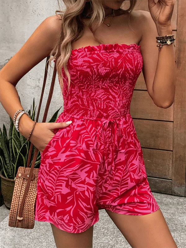 Strapless red and pink leaf print romper with smocked bodice and tie waist.