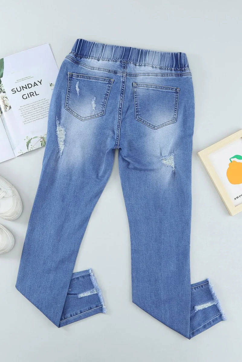 Light blue distressed denim jeans with frayed hems, showing the back with two pockets.