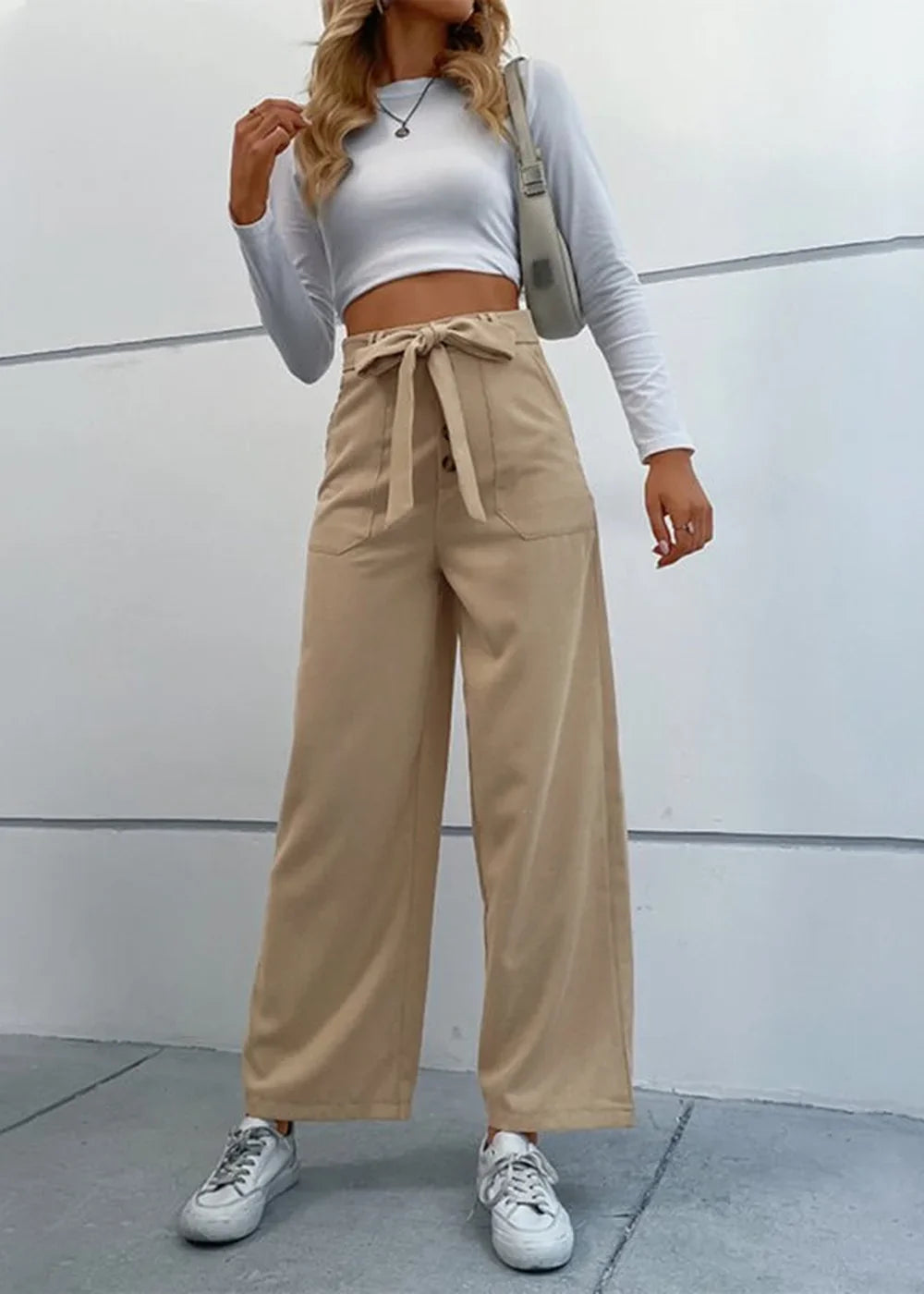 Khaki wide-leg pants with a tie waist and button detail, on a model.