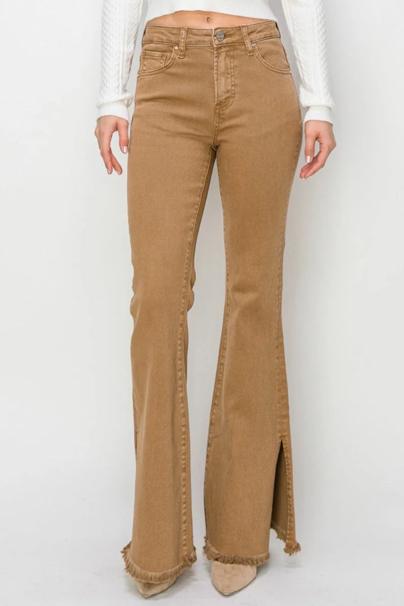 High-waisted brown flare jeans with frayed hem and side slits on model.