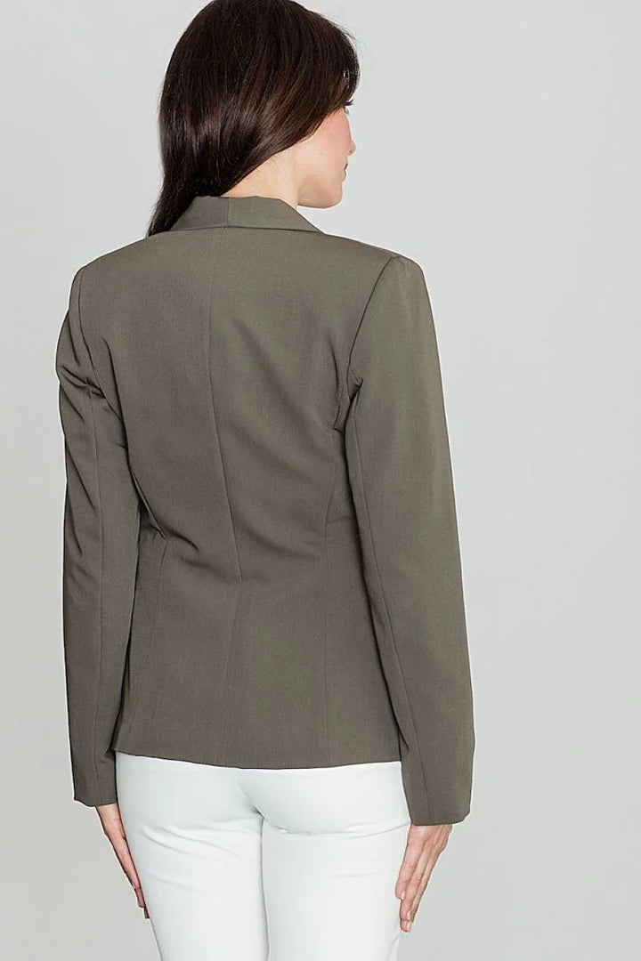Back view of a woman wearing a dark olive green blazer with a smooth texture and white pants.