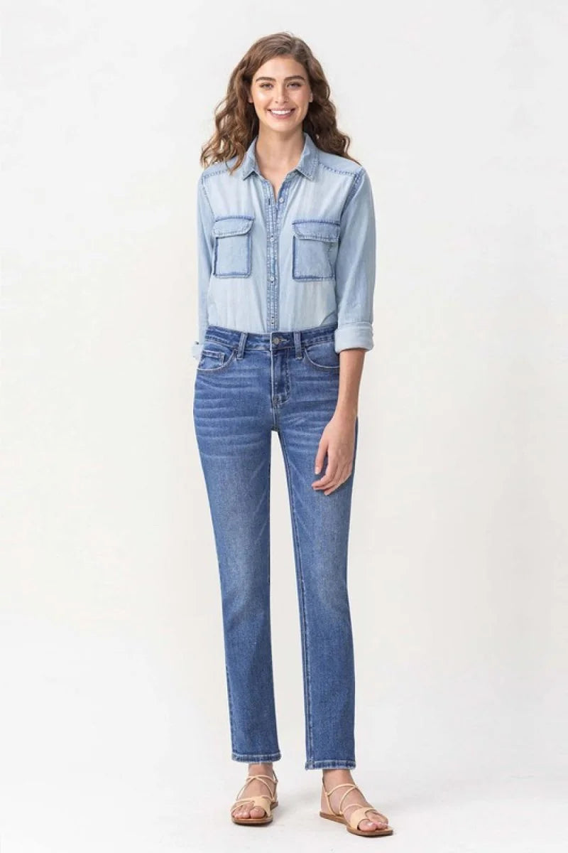 Full-length shot of a woman wearing light wash, straight-leg denim jeans with a regular fit.
