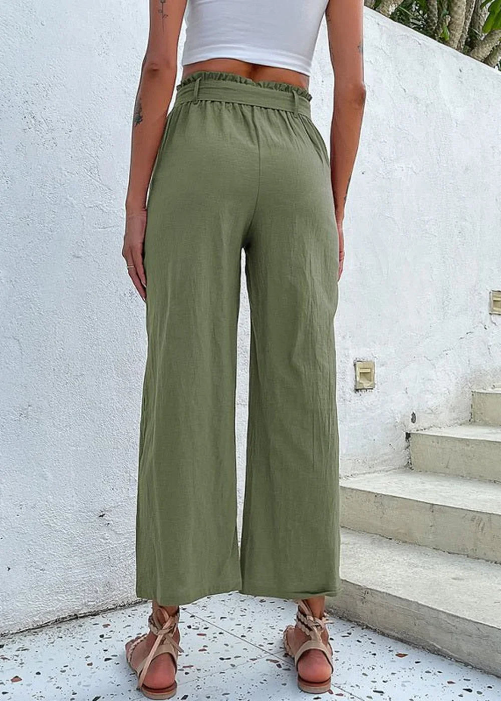 Olive green wide-leg cotton pants with ruffled paperbag waist and tie belt, shown from the back.