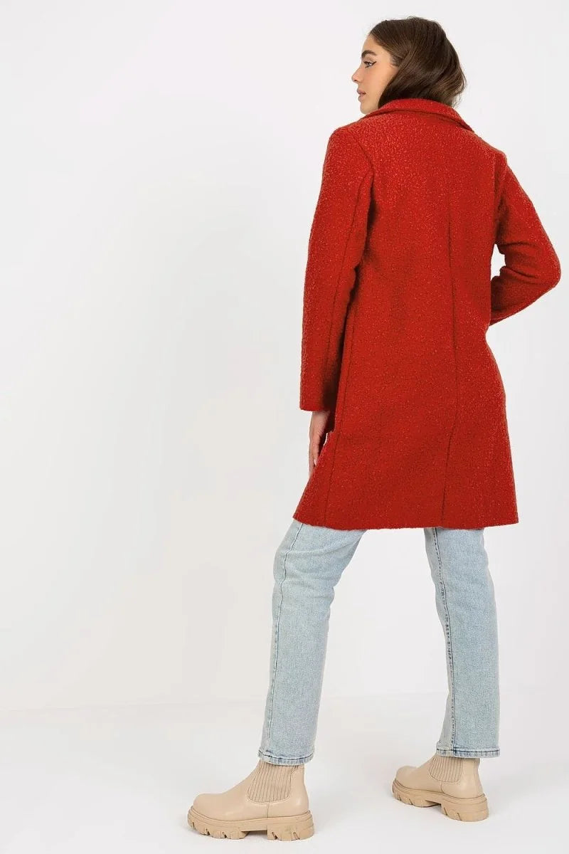 Red textured boucle coat with light blue jeans and beige boots, back view on model.