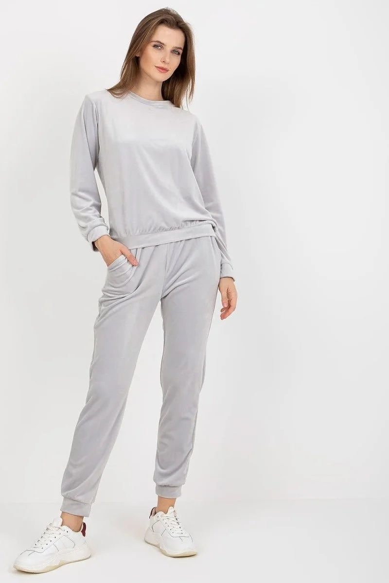 Light grey velour tracksuit with a crewneck sweatshirt and elastic waist pants, worn by a model.